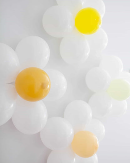 White and pastel balloons arranged in a floral pattern, featuring yellow and green accents.