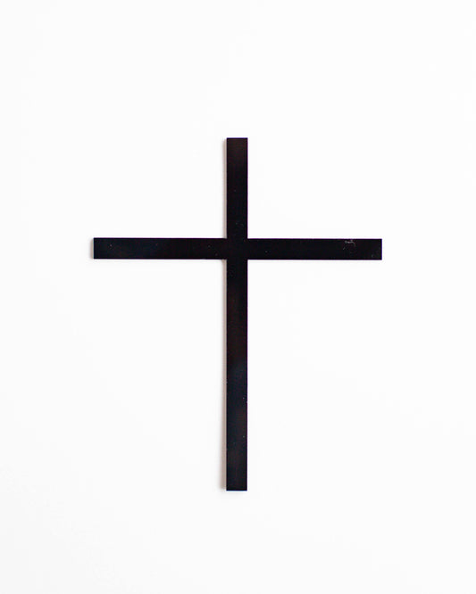 A simple black cross centered against a clean white background, emphasizing minimalism and spirituality.