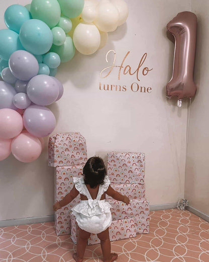 A colorful balloon garland with pastel shades and a large "1" balloon, celebrating a child's first birthday.